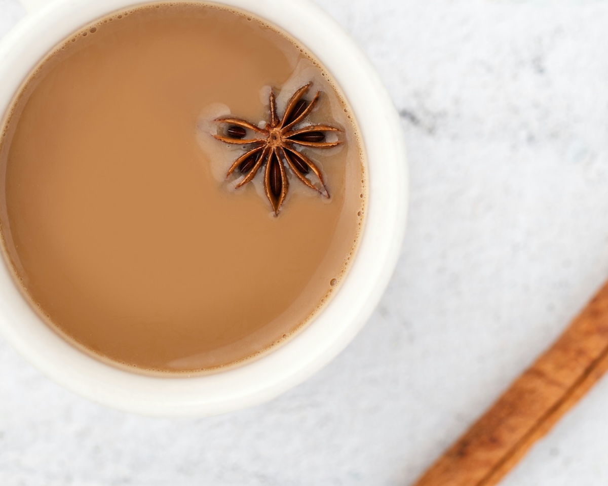 Overhead view of chai latte with star anise garnish in white cup
