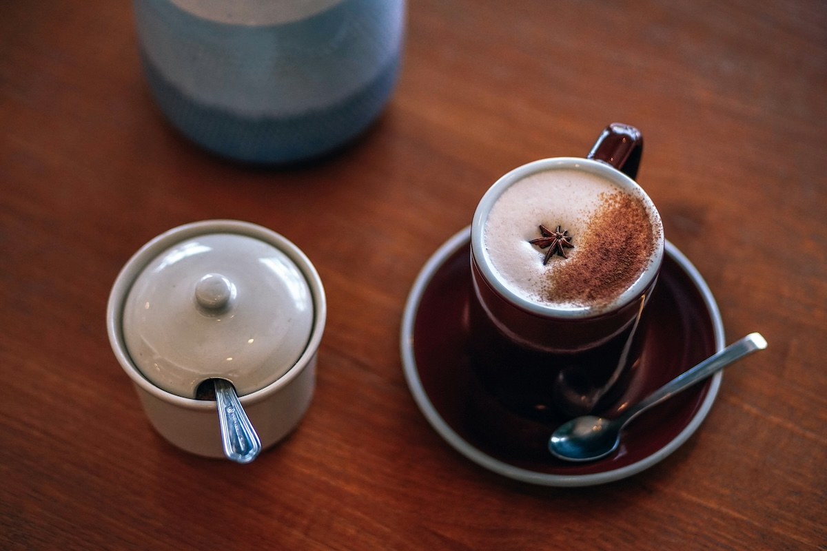 Chai latte with star anise garnish on rustic wooden table