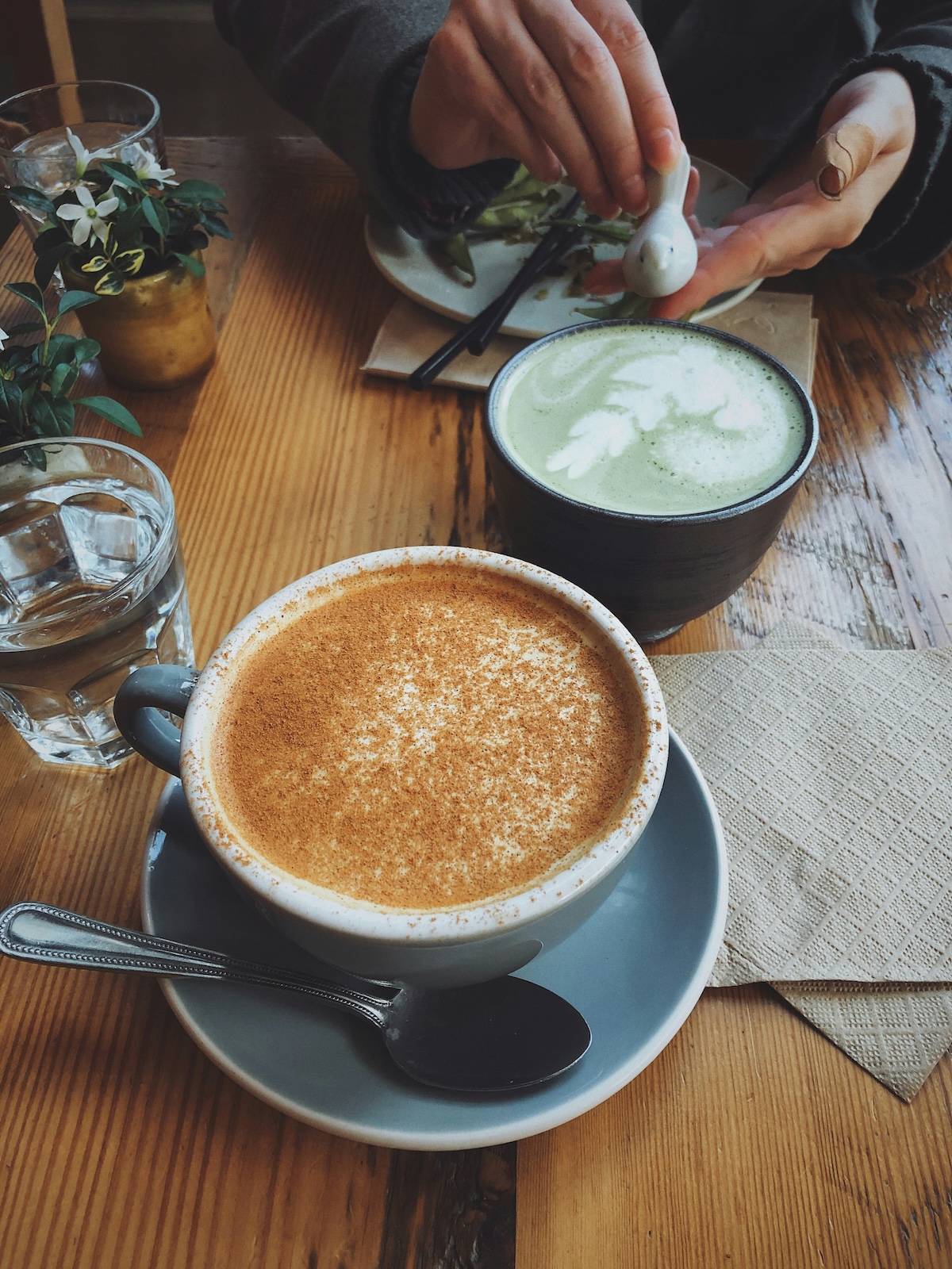Chai latte and matcha latte side by side on cafe table