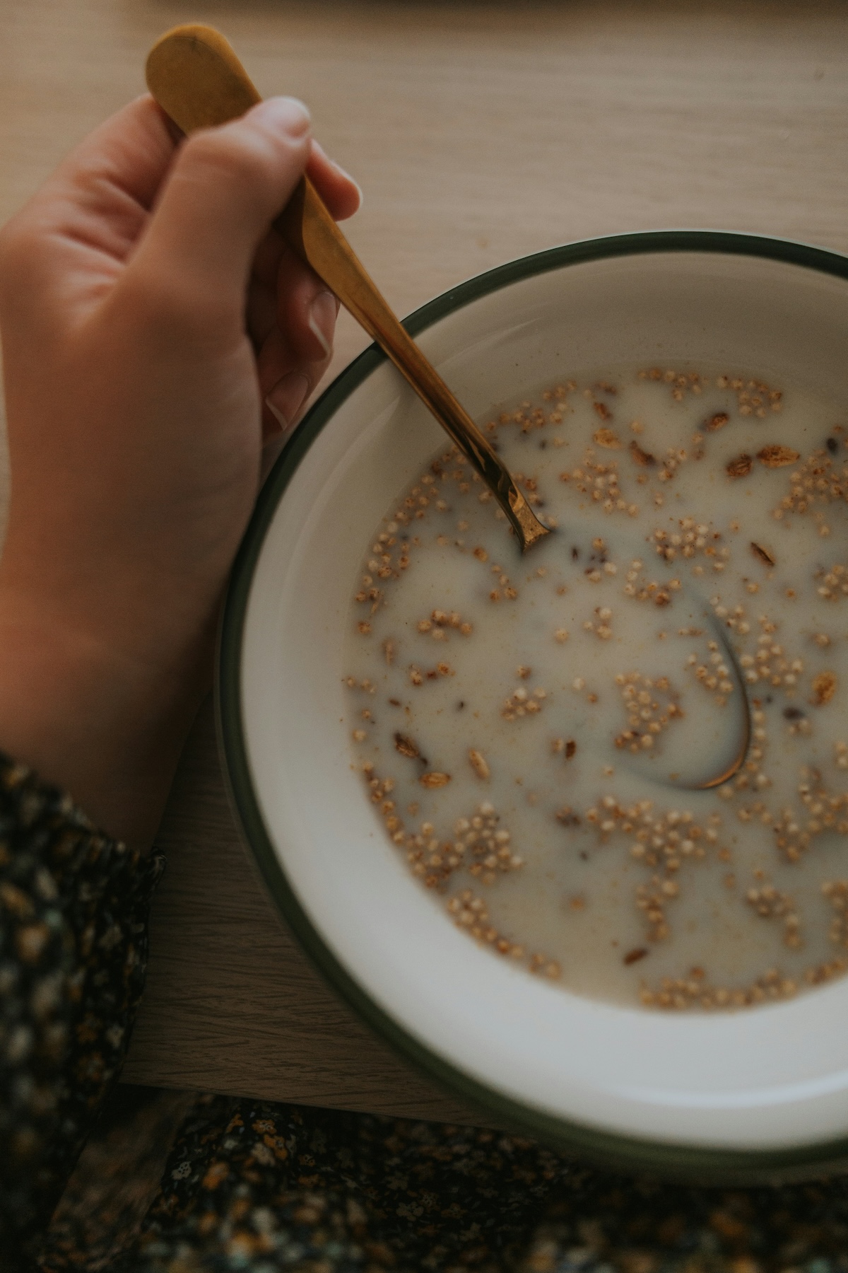 Hand holding bowl of cereal with plant-based milk