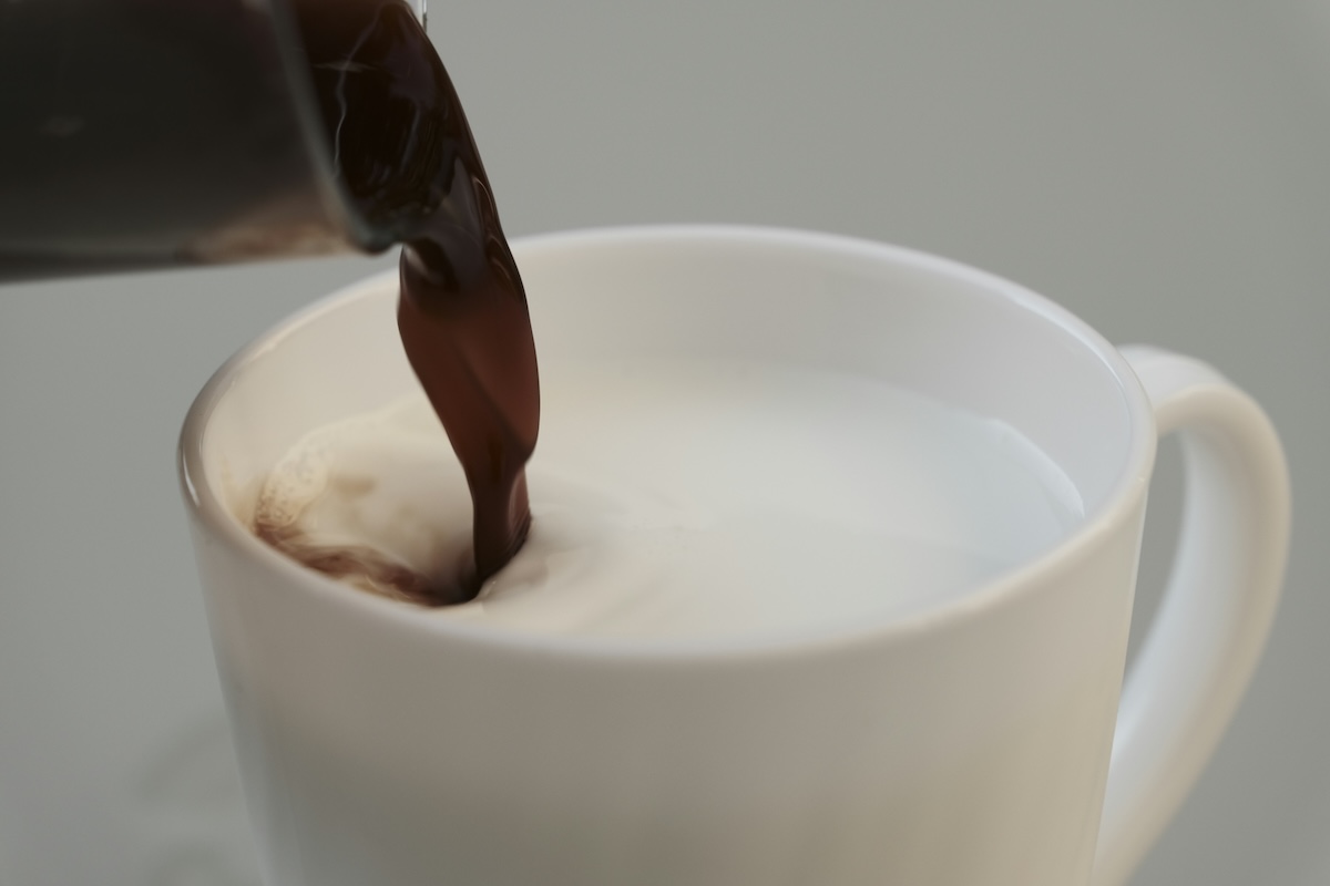 Rich dark chocolate being poured into a white mug