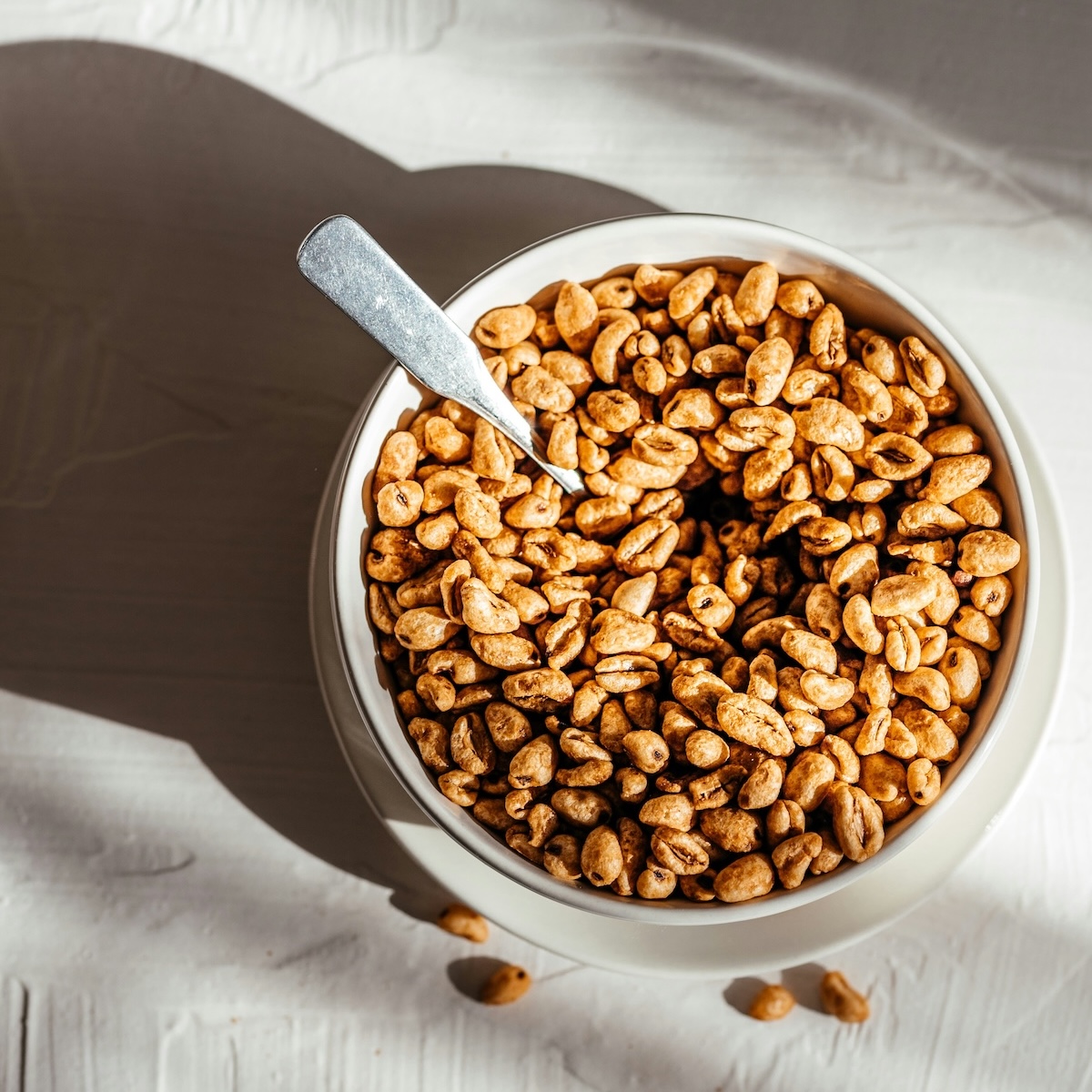 Bowl of puffed cereal with spoon in morning light